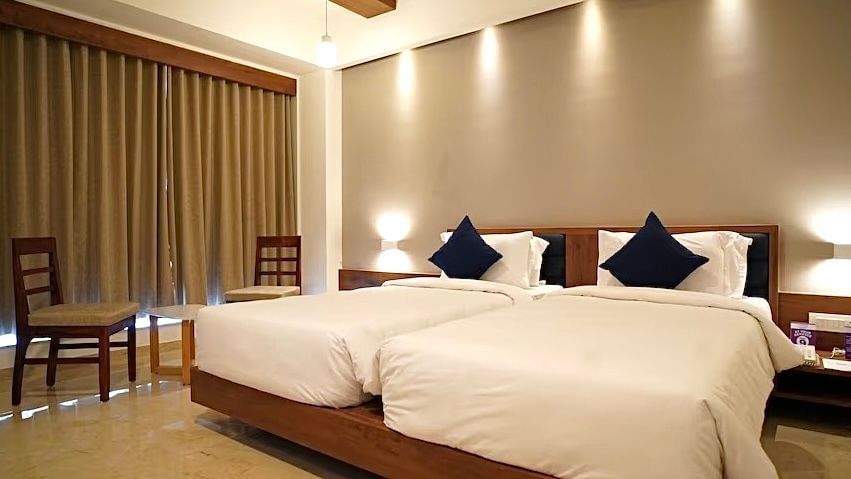 Executive Twin Room with two beds, modern decor and warm lighting at VITS The Somnath Gateway.