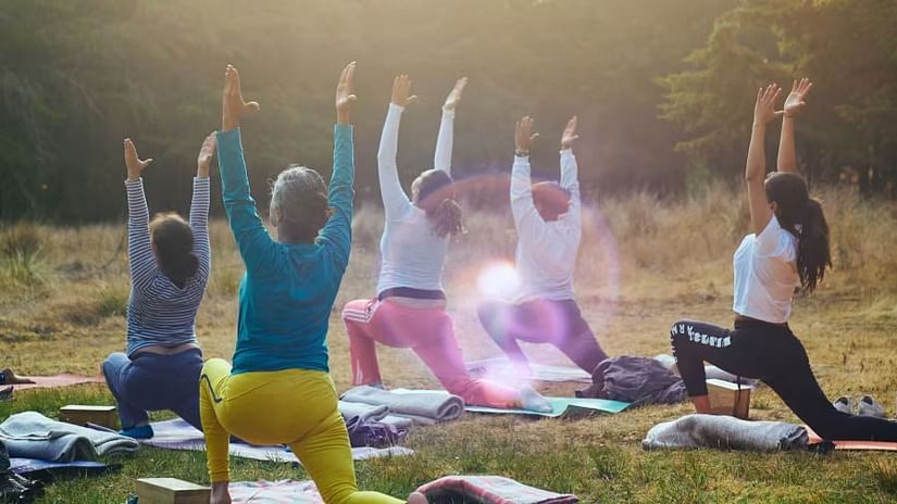 A group of women performing a yoga pose on the garden - Karma Lakelands.
