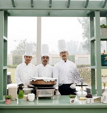 Chefs standing behind an outdoor cooking counter at Nirvana Luxury Hotel, Ludhiana