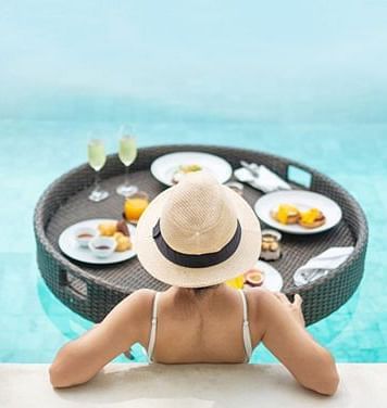A lady enjoying breakfast in the swimming pool at Nirvana Luxury Hotel, Ludhiana
