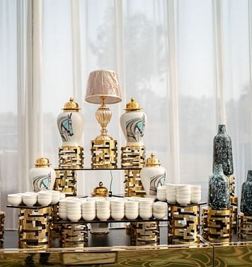 Candles placed on a table with a large window in the backdrop at Nirvana Luxury Hotel, Ludhiana