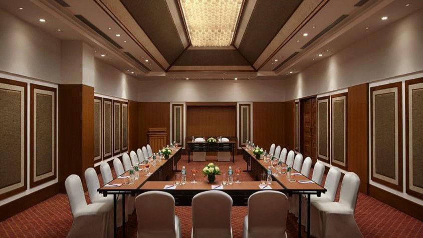 A sophisticated conference room setup with a U-shaped table arrangement, surrounded by elegant chairs, perfect for business meetings and presentations.