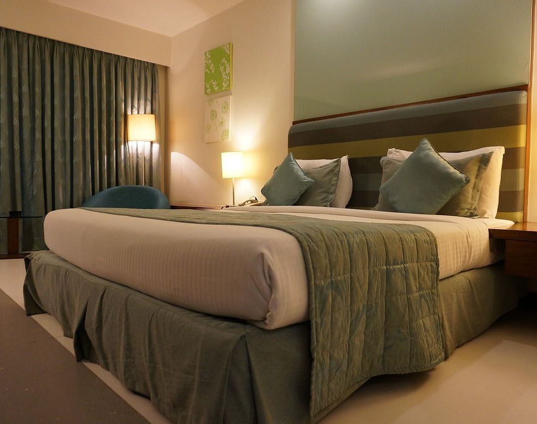 Image of a bedroom with a large bed, side tables, and lamps.