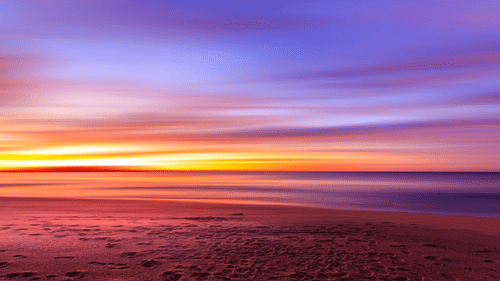 An overview of the sky with different hues after the sunset as seen from a beach