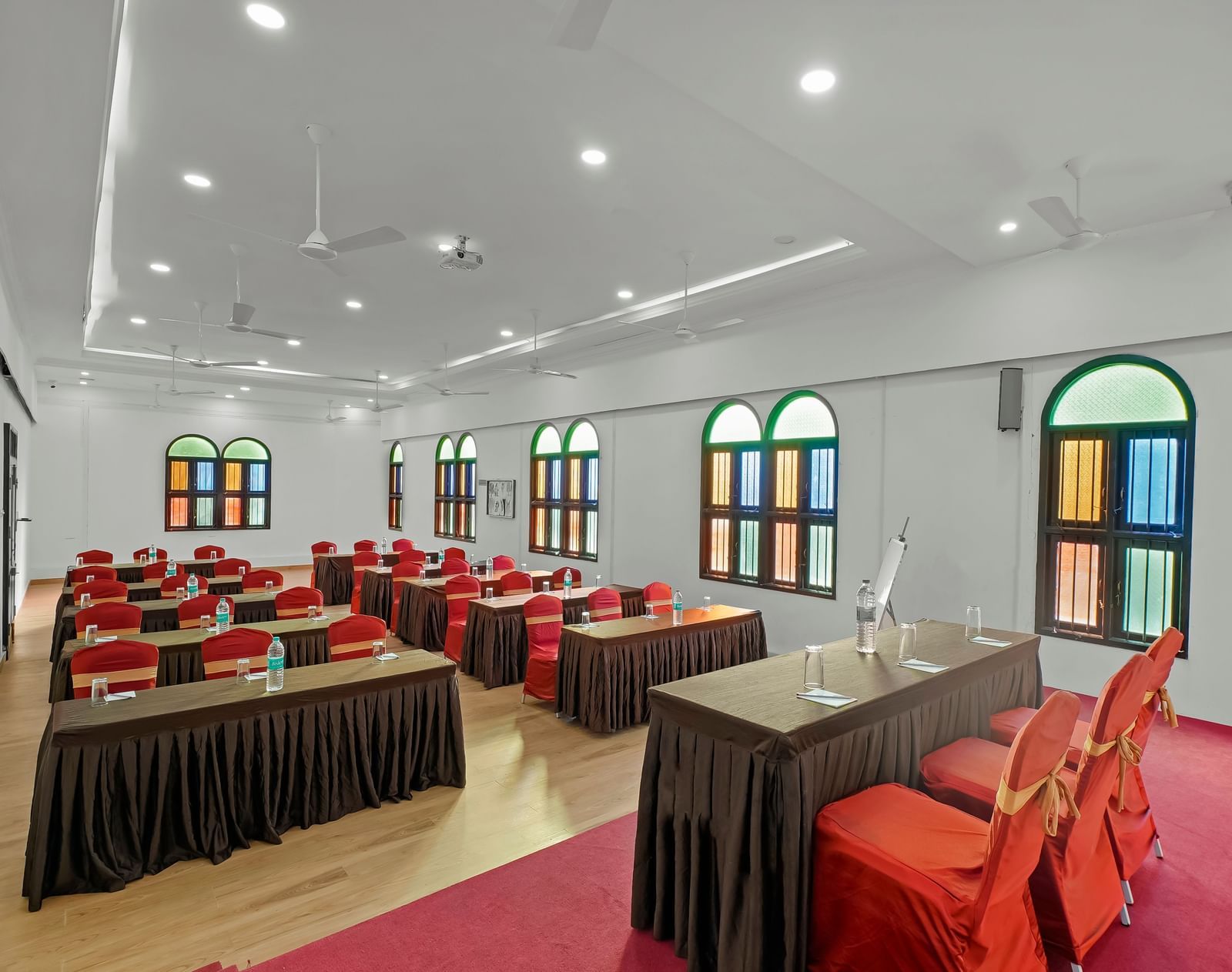 Diagonal view of a banquet hall with tables and chairs arranged for an event at WOW Bungalow, Yercaud.