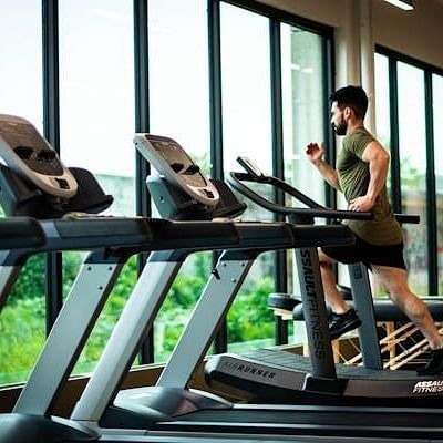 A man running on a threadmill at a gym.