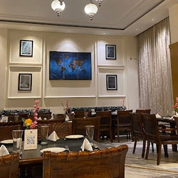 Full view shot of the Gold Plate restaurant with several photo frames wall mounted behind the dining tablesCorner view shot of the dining area of the Gold Plate restaurant with central air-conditioning and a small cabinet in the corner of the restaurant - 
