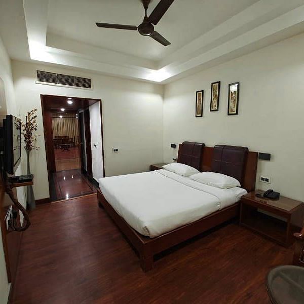 The bedroom of the Suite featuring a plush double bed with minimalist interiors - Hotel Gold, Panipat