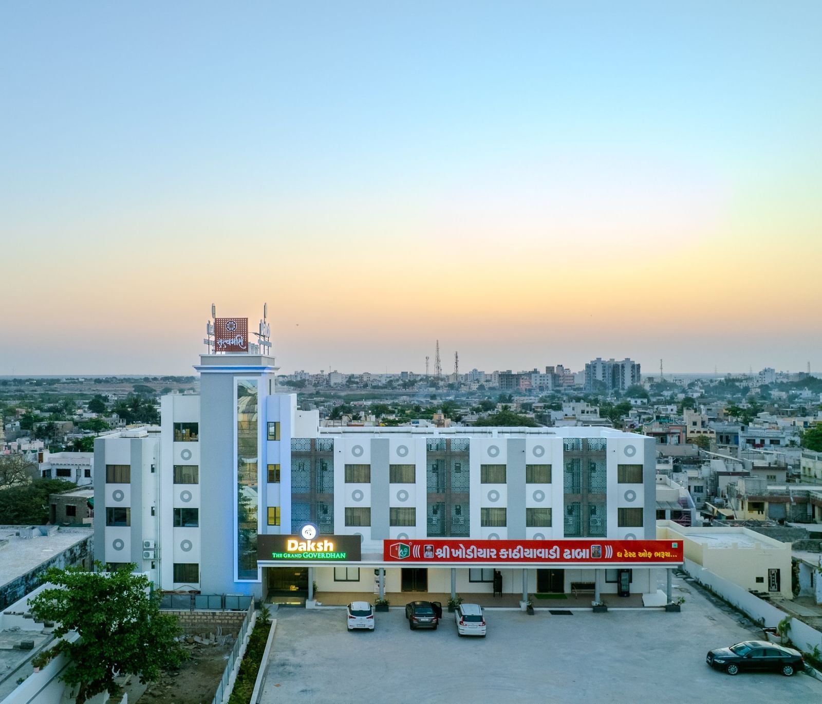 Expansive aerial view of Daksh The Grand Gowardhan, Dwarka, at dusk, revealing its impressive scale amidst the surrounding landscape.
