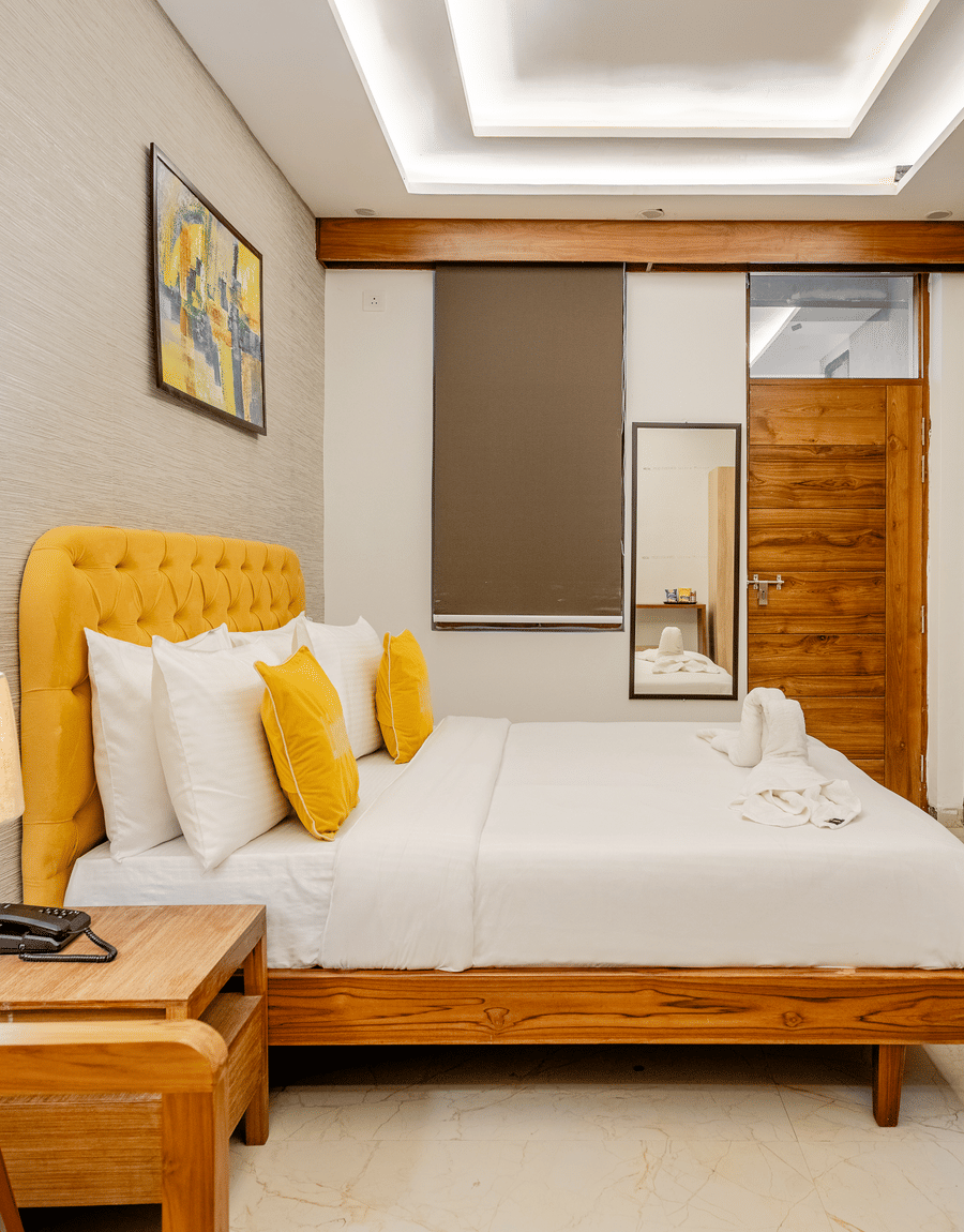 Comfortable hotel room setting with a large bed, bedside lamps, and a wooden feature wall.