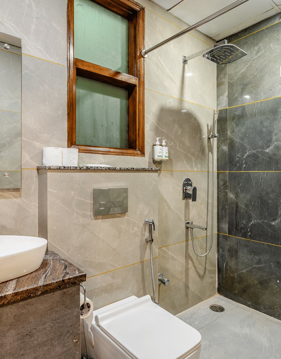 Bathroom with a rain shower, grey tiles and a wall-hung toilet in the Superior Double Room at Lime Tree Hotel Near Medanta