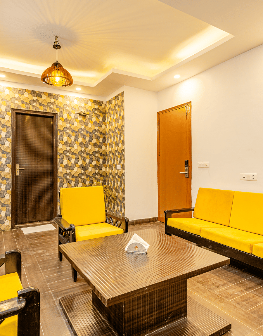 Yellow sofas in the living room of the Suite at Lime Tree Hotels and Banquet Hall Near Huda Metro, Gurgaon