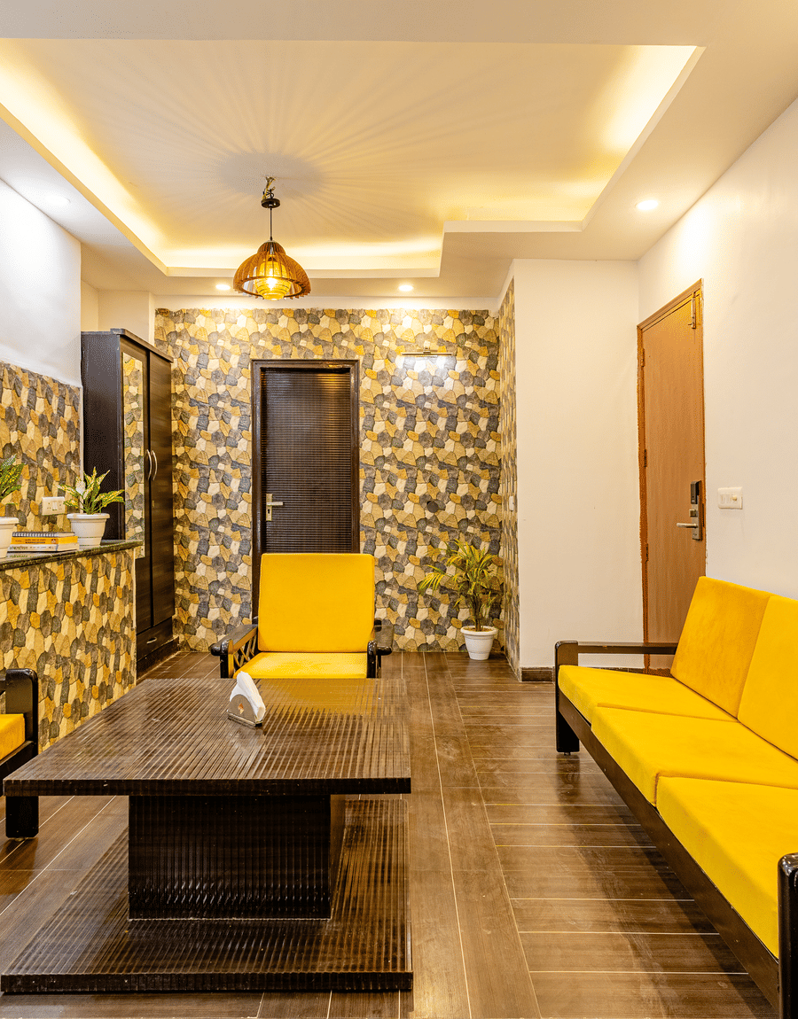 Seperate living room with yellow sofa setup in the suite at Lime Tree Hotels and Banquet Hall Near Huda Metro, Gurgaon