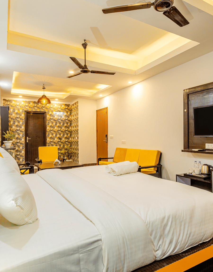 Side view of the king size bed in the suite at Lime Tree Hotels and Banquet Hall Near Huda Metro, Gurgaon