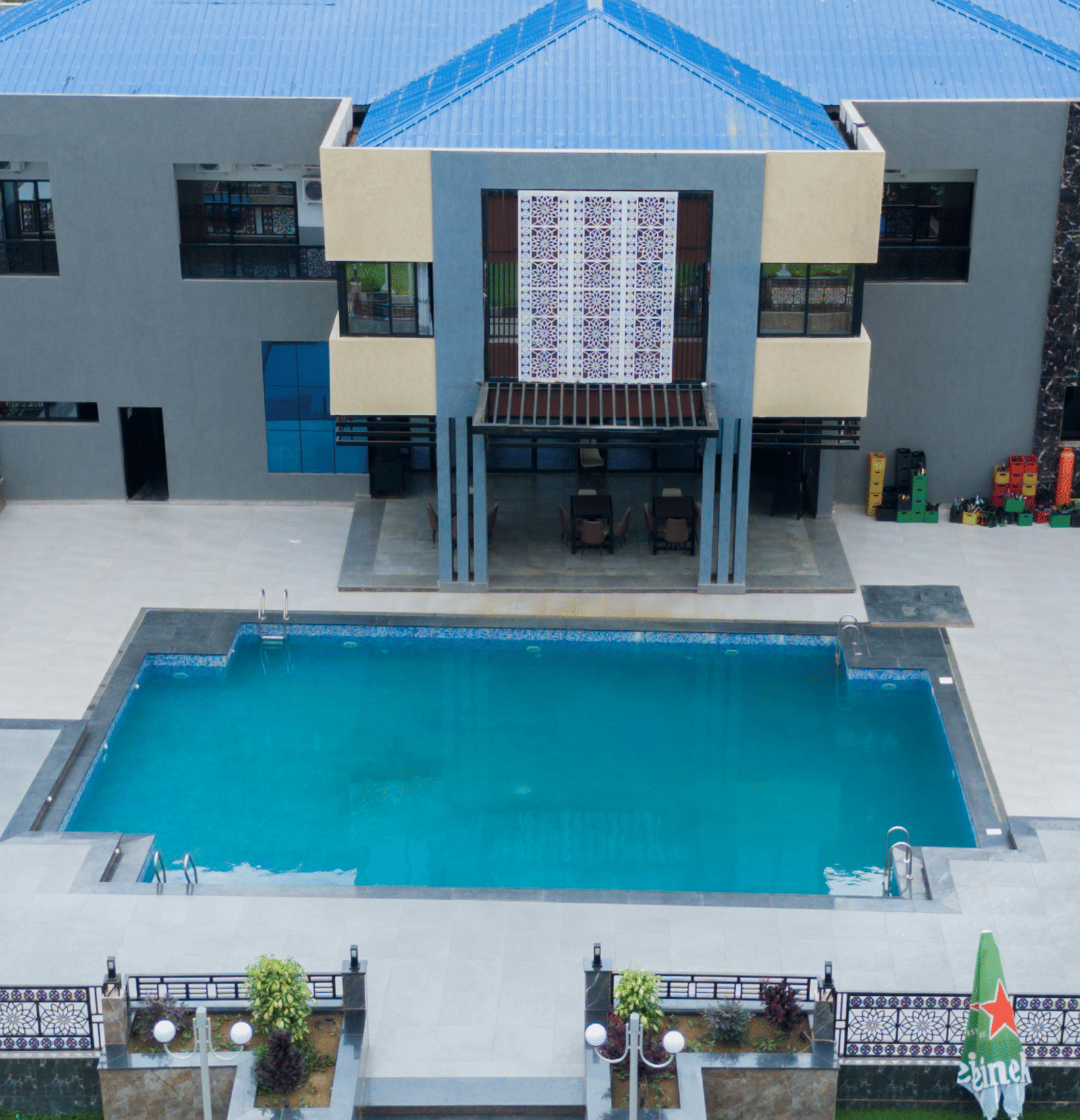 Aerial view of a modern building with a swimming pool and landscaped grounds - Luffu Club
