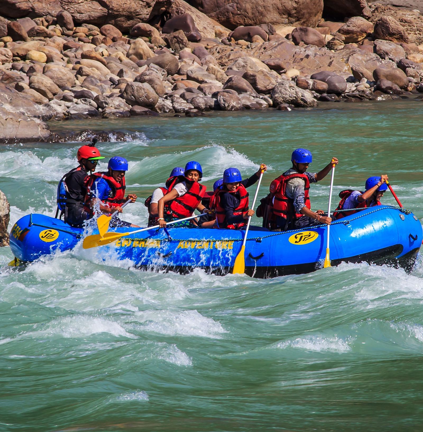 image of a group of tourists experiencing river rafting in the rapids in rishikesh