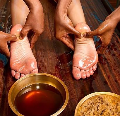 a person getting a foot massage with oil and ayurvedic paste at Ocean Spray Puducherry 
