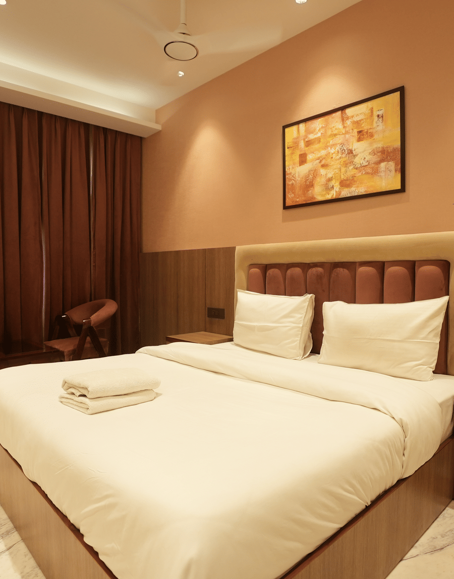 Warm-toned room with king size bed and curtains at Lime Tree Hotel Near India Expo Mart, Greater Noida.