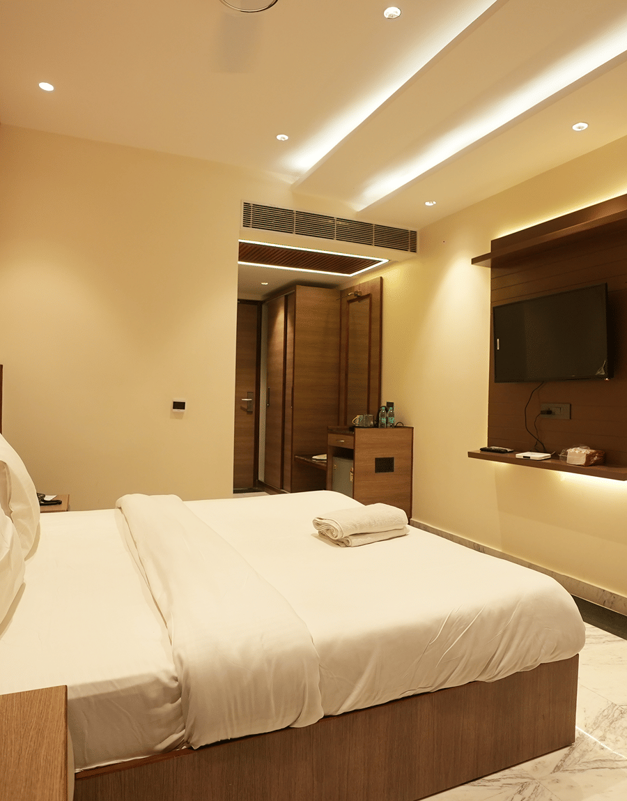 Modern guest room with king size bed and wood accents at Lime Tree Hotel Near India Expo Mart, Greater Noida.