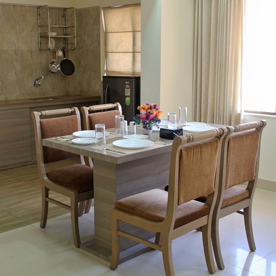 A dining area featuring a table anf chairs - Maxxvalue Apartment Marol