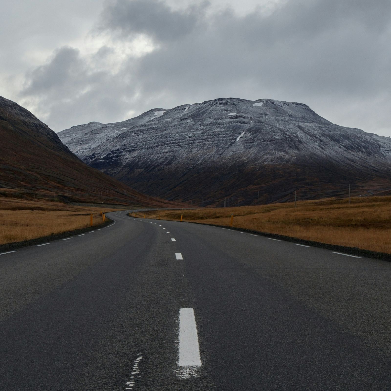 An overview of a highway with single lanes on either side and a mountain in the background.