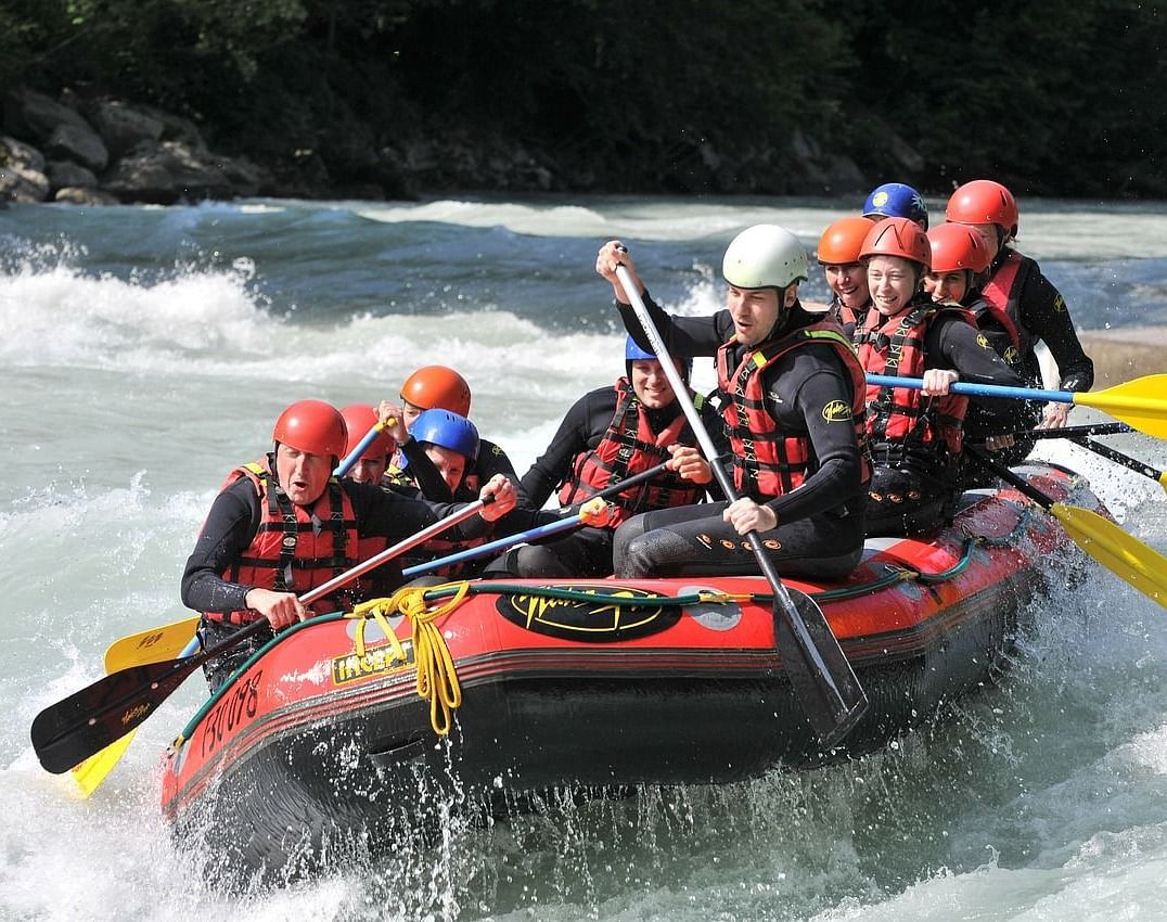 Group of people whitewater rafting on a river.