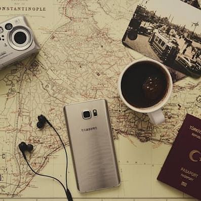 Image of phone and camera with other accessories arrnaged on the table 