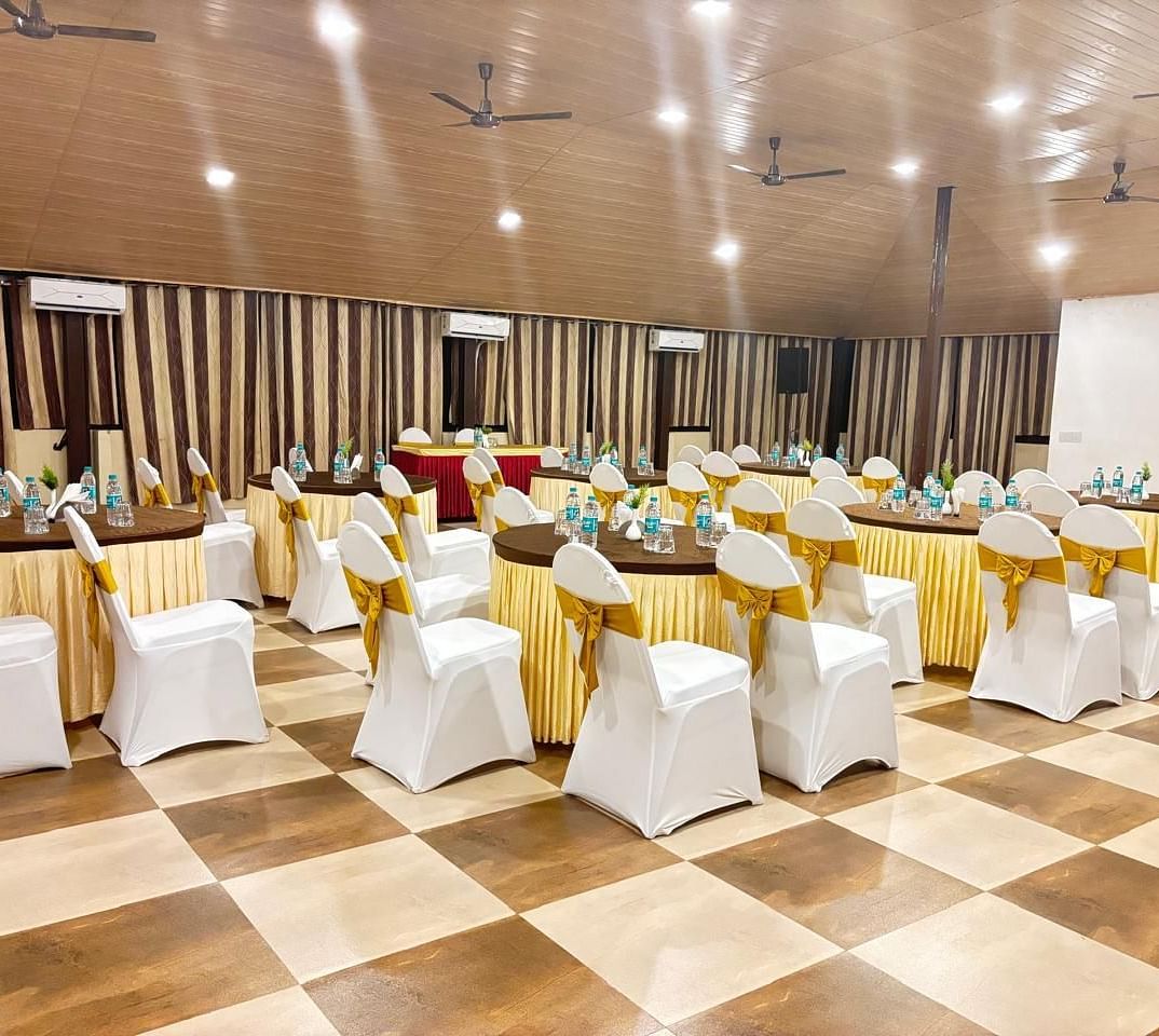 A banquet hall, highlighting the lighting and chairs facing a white screen | Ballroom | Woodstock Resorts, Coorg