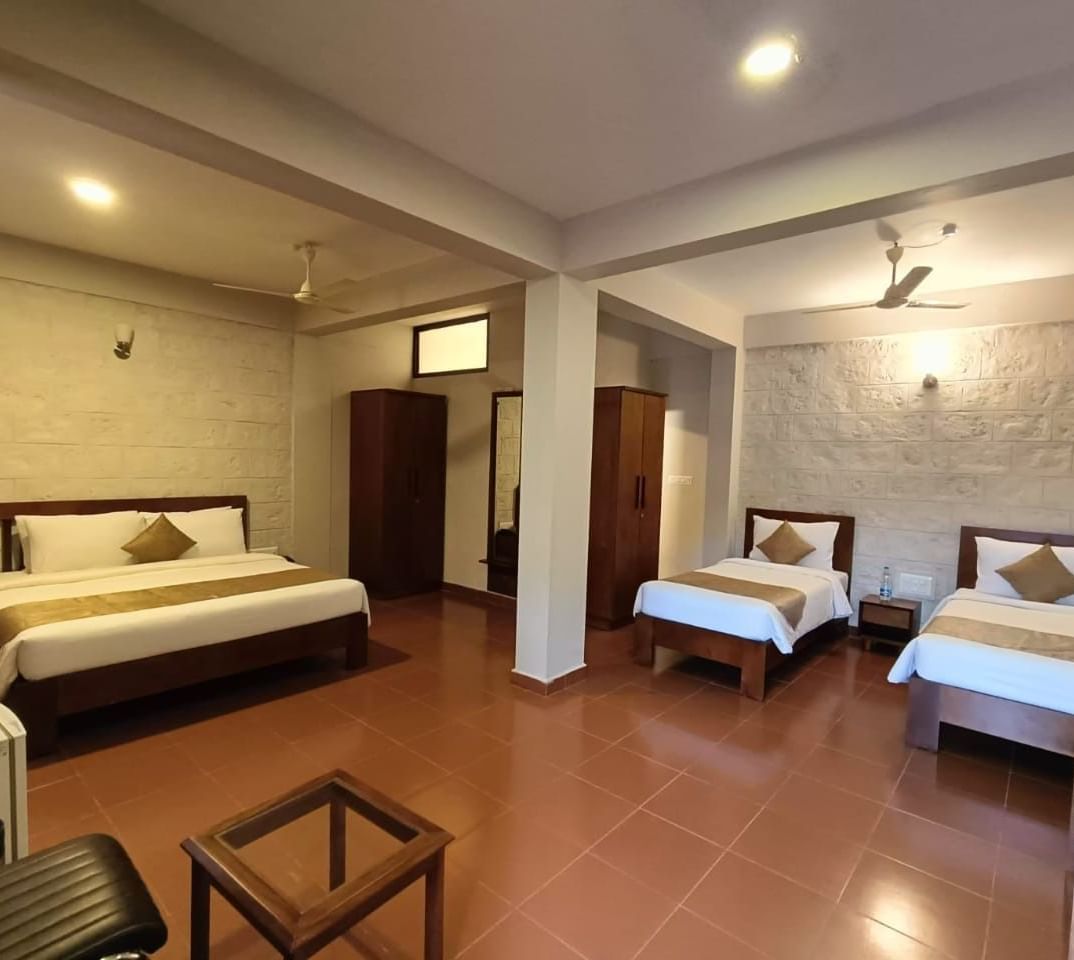 Elegant Deluxe Family Room at Woodstock Resorts, Coorg with twin beds, spacious layout, and warm, inviting interiors.