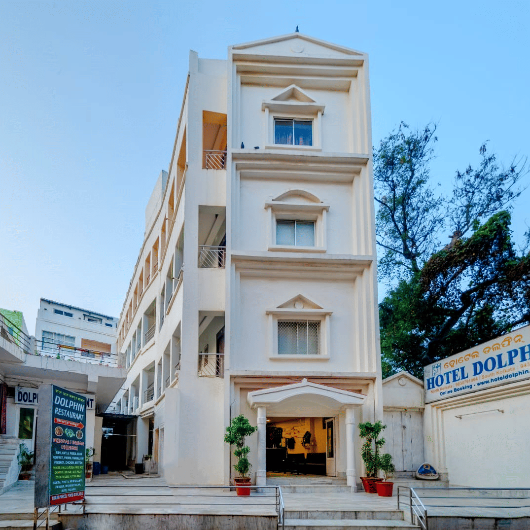 Front facade of Hotel Dolphin Puri with entrance signage and exterior architecture.