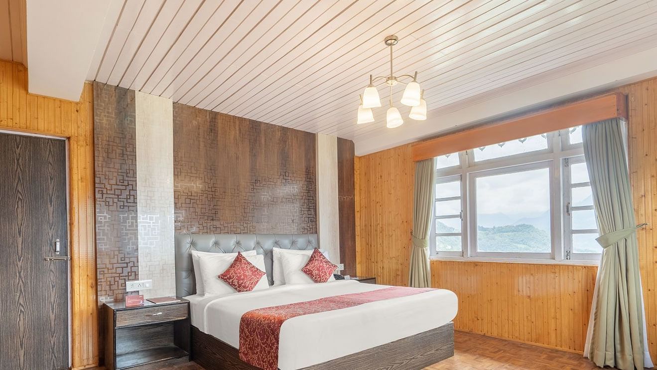 Image of a room with bed and a chandelier hanging from the wall at Summit Tashi Ghang Heritage Resort, Pelling