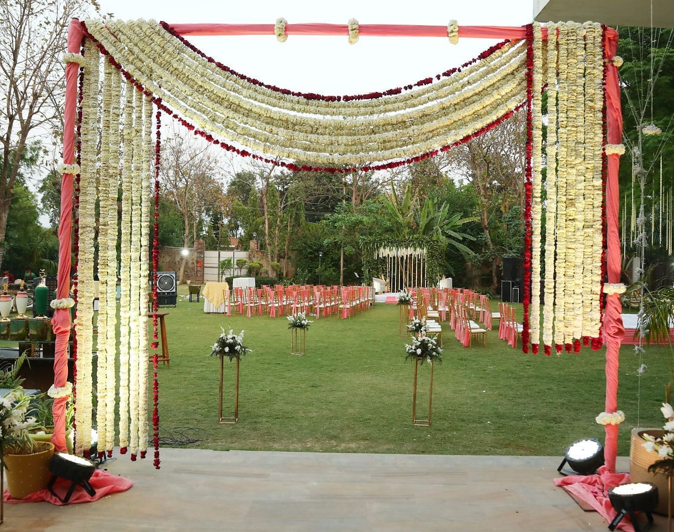 Entrance gate at Tisya Farms, Gurgaon decorated with fabric, lights, and flowers in a symmetrical arch.