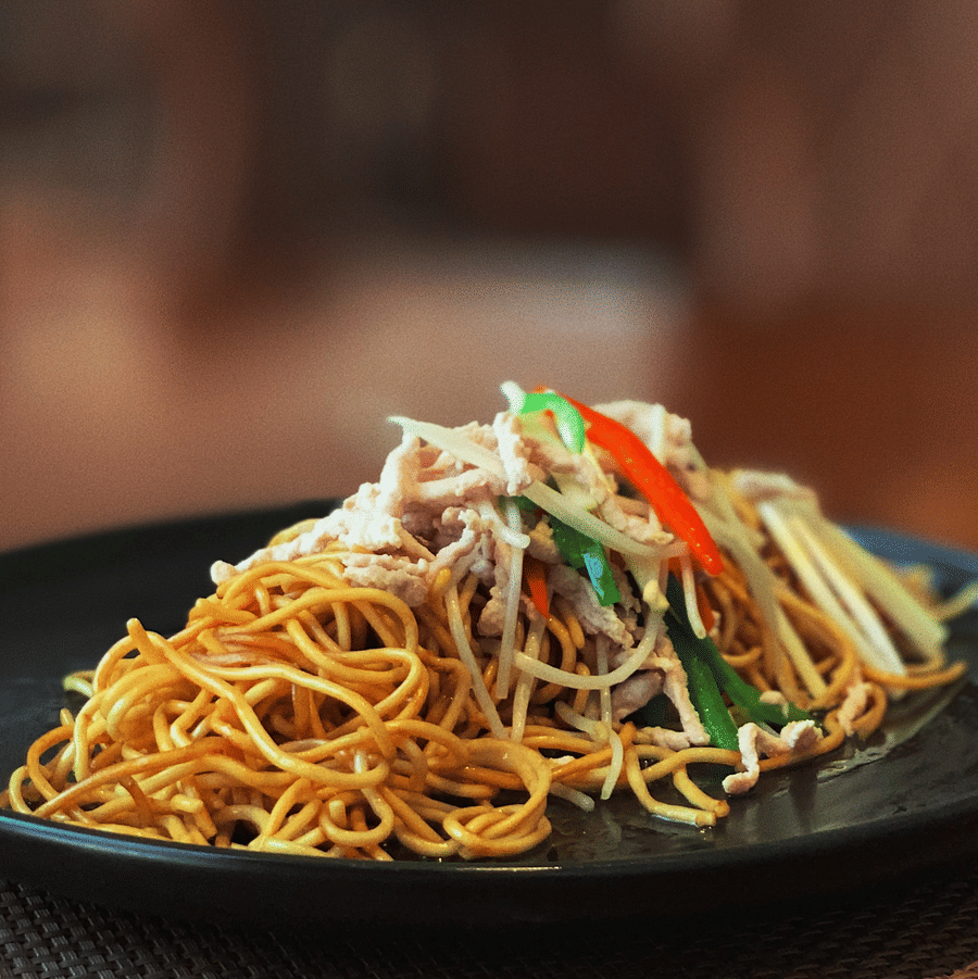 Noodles served in a black ceramic plate.