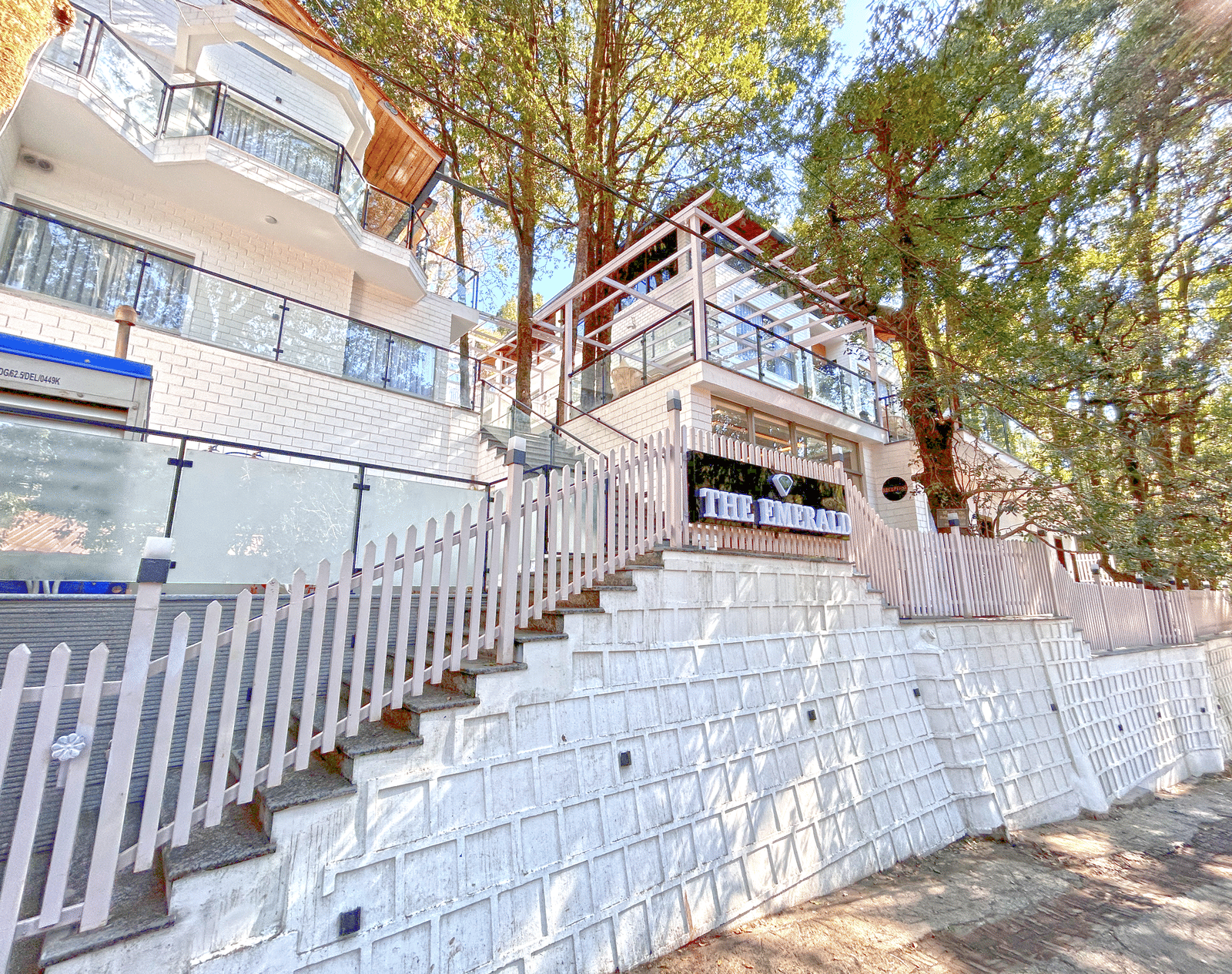 A facade image of DLS The Emerald, Nainital surrounded by tress and lush greenery