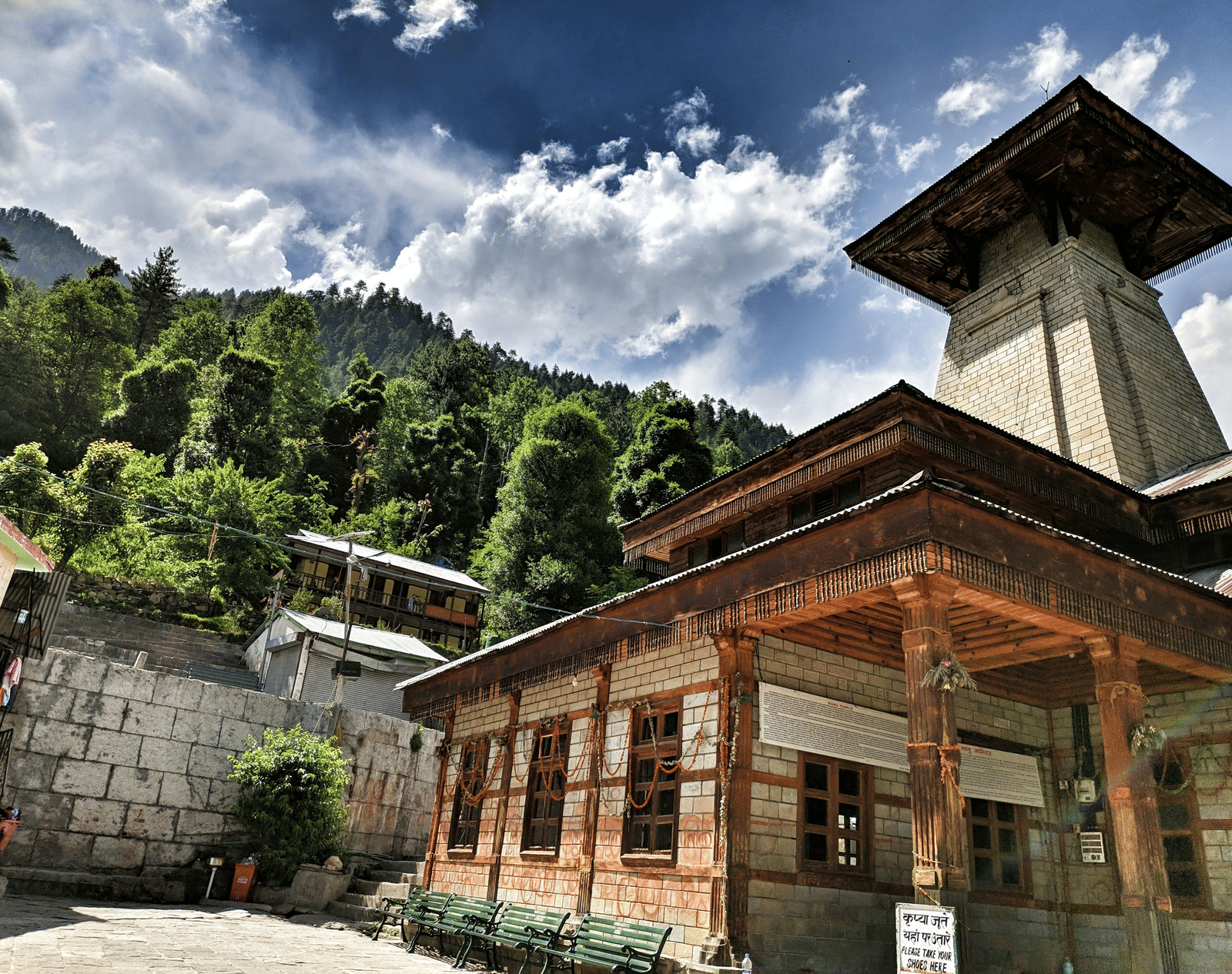 An overview of Manu Temple in Manali with a mountain and blue sky in the background.