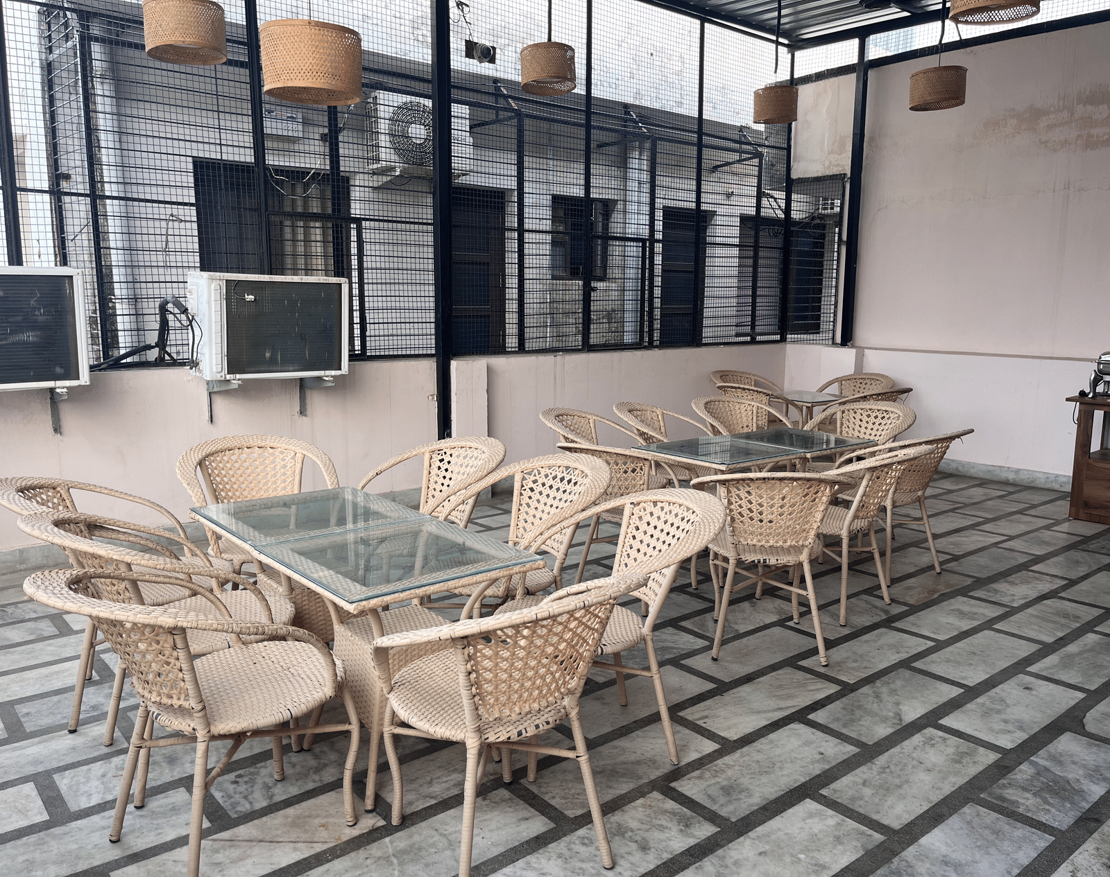 Corner view of the dining area in the rooftop of the Perfectstayz Value Dhruv Nanda, Haridwar, with a metal grill covering the perimeter.