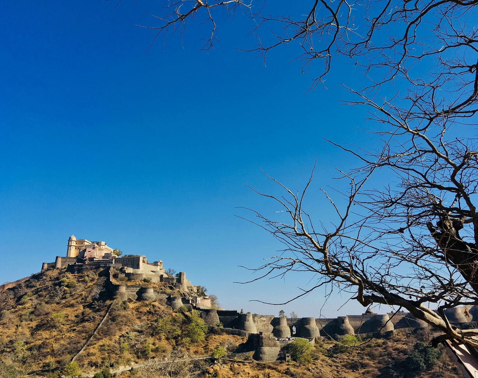 A fort with stone structure on a hilltop under a clear blue sky.