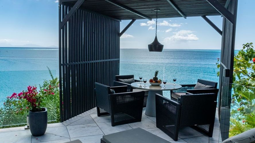 Elegant outdoor dining setup with stunning sea views at Tamarind Hills Antigua – Resort & Villas