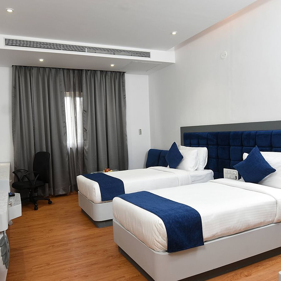 A full view of twin beds with bedding in a spacious room