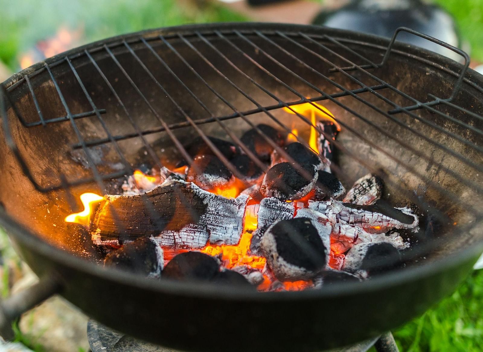 An image of a grill with bright flame and coal.