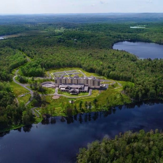 Aerial view of YO1 Health Resort surrounded by lush greenery and scenic lakes in Catskills, New York.