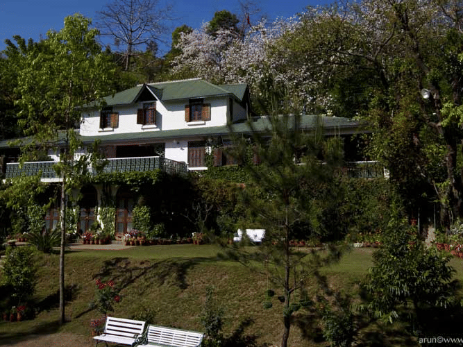 Exterior of Shaheen Bagh Resort Dehradun on a sunny day nestled in greenery