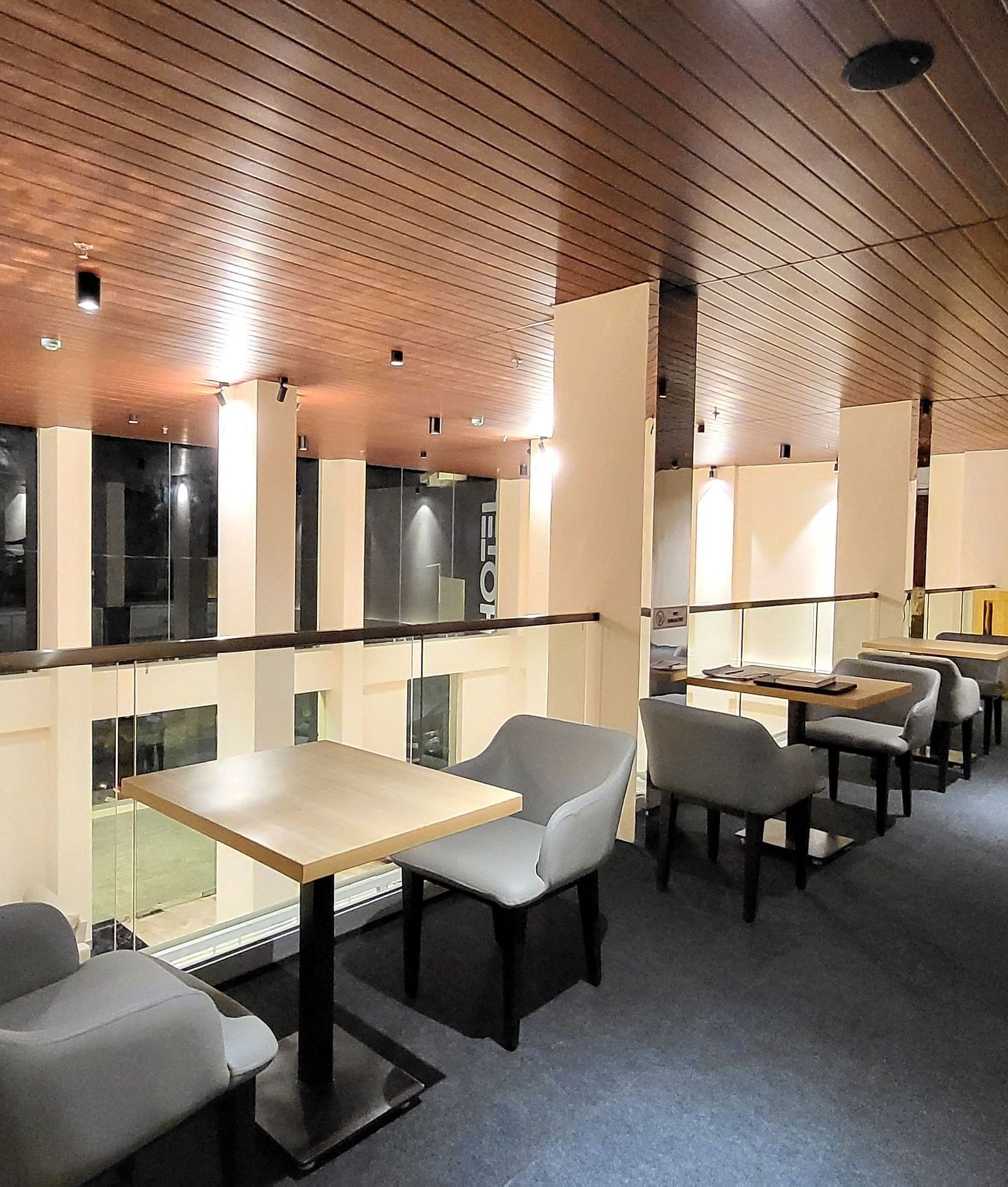 Grey chairs kept facing each other with a small tea table in the middle at in 6ix Sea View Restaurant at 6ix Seashore Hotel, Port Blair