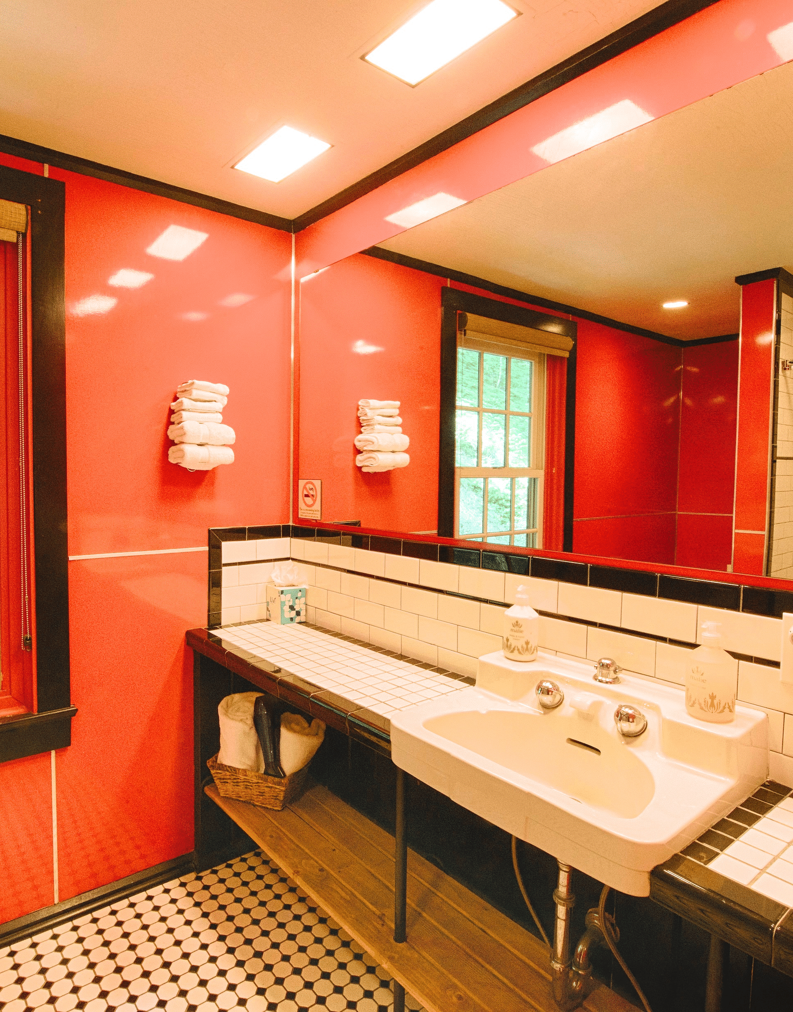 a bathroom with a washbasin along with a huge wide mirror above it - Historic Tapoco Lodge