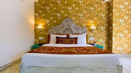 Image of a room with wooden bed and lamps on the side of the bed at Summit By The Ganges Beach Resort & Spa, Rishikesh