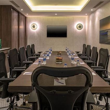an interior of a conference furnished with a table and chairs around it at an event hall decked with rows of chairs at The Residency Towers Rameswaram