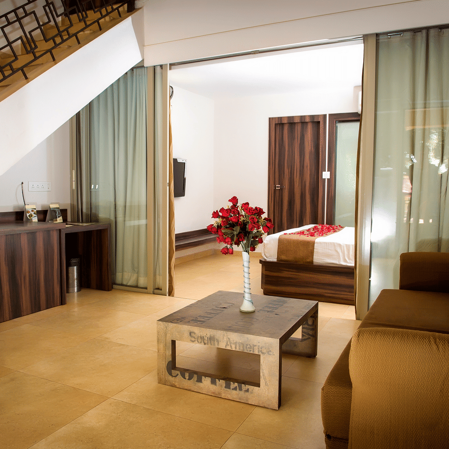 Deluxe villa bedroom living  room interior featuring a sofa and coffee table - Adamo Resort Matheran.