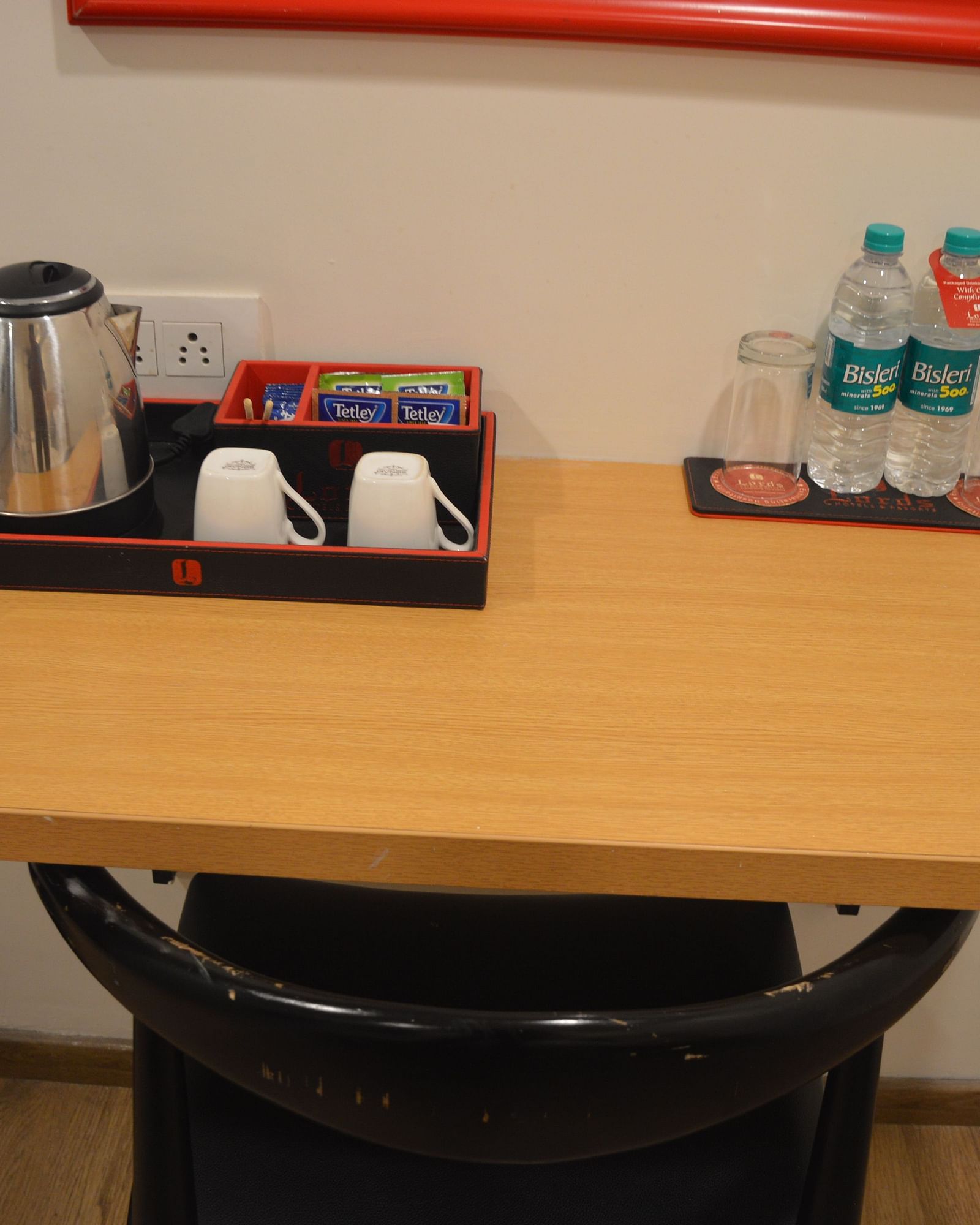 Tea and coffee making station on a table with a kettle and supplies - Lords Eco Inn Belagavi
