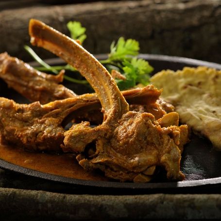 Mutton chops curry with flatbread and cilantro.