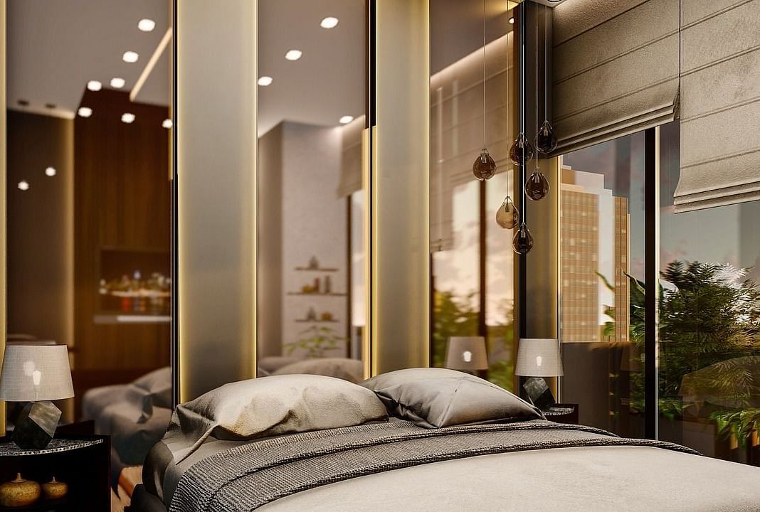 A room with chic and modern interiors with tall mirrors behind the bed.